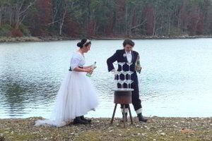 Happy couple of brides with stacked champagne glasses at beach near Bruny Island Lodge